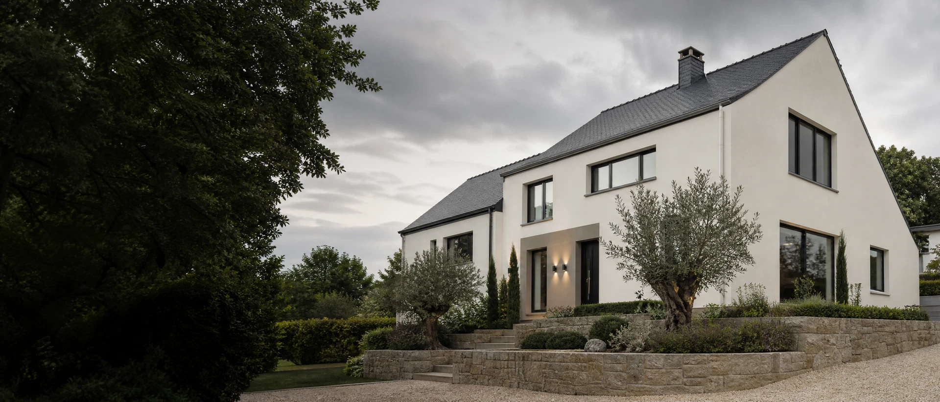 Maison contemporaine avec façade minérale claire et mur en pierre